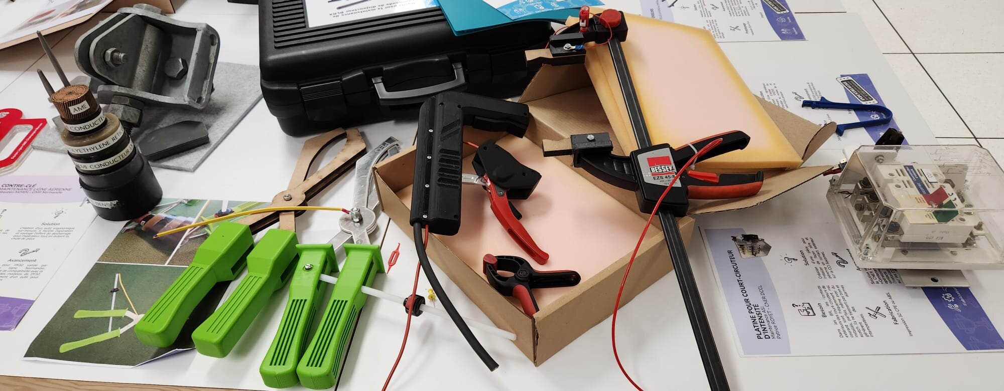 Outils, pinces et prototypes posés sur l'établi pour une session de méthode