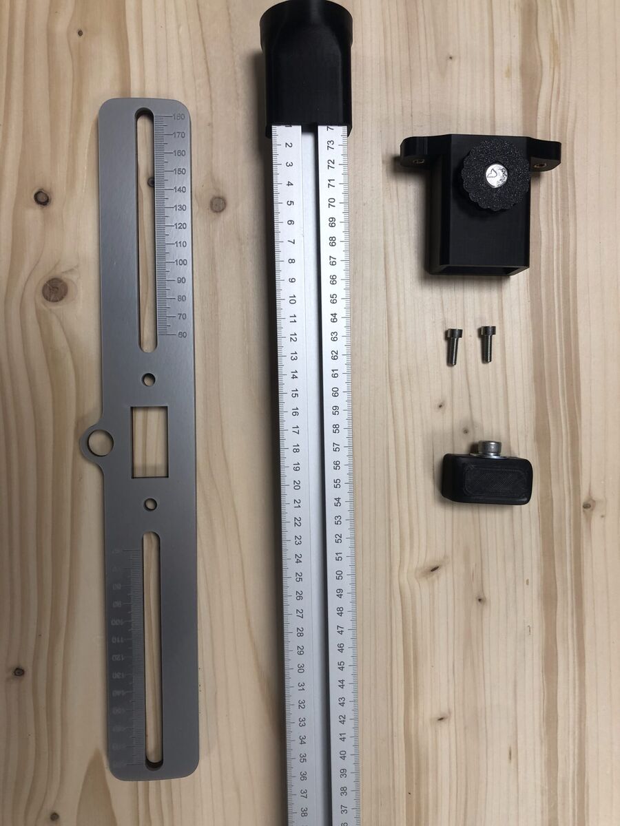 Gabarit de pose en aluminium, réglet et fixations imprimées posés sur un établi